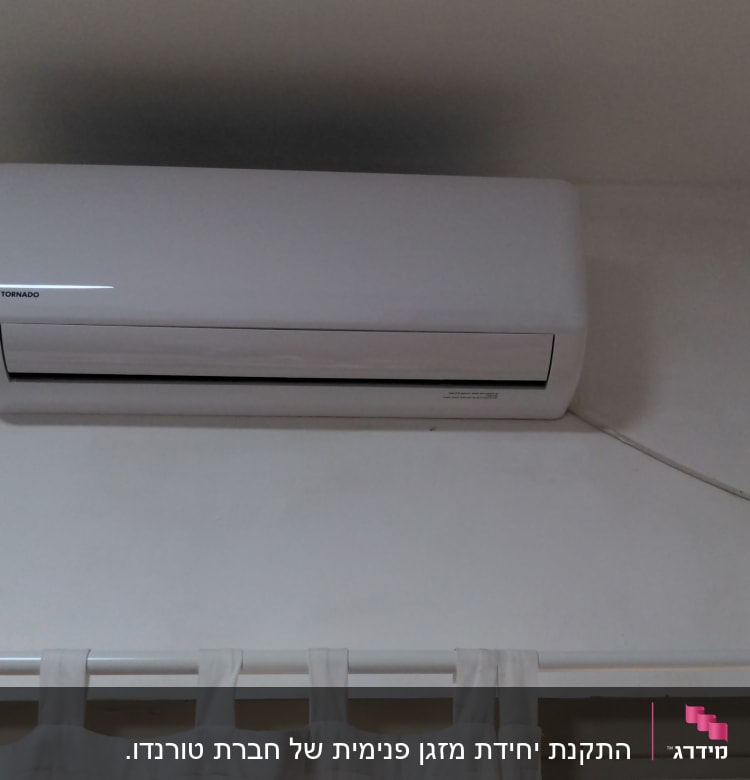 יחידת מיזוג אוויר מותקנת על קיר לבן